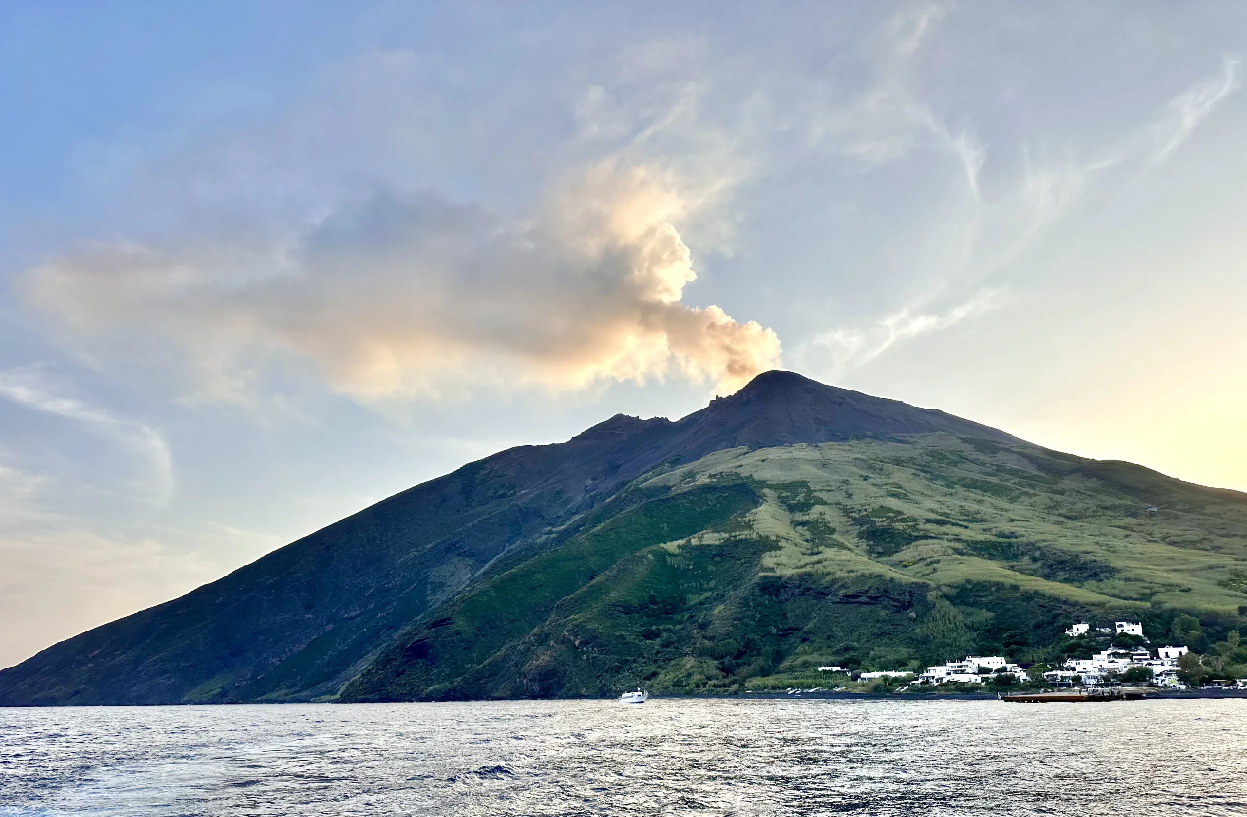 Vista di Stromboli dal mare con fumo dal cratere al tramonto