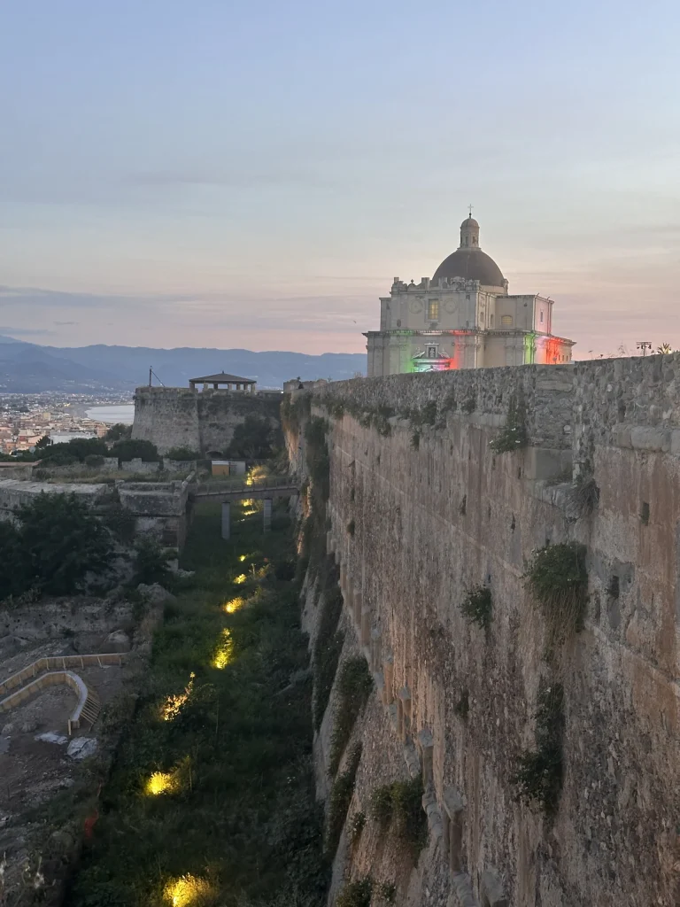 Vista serale del Bastione di Santa Maria con la cupola illuminata e il fossato in primo piano